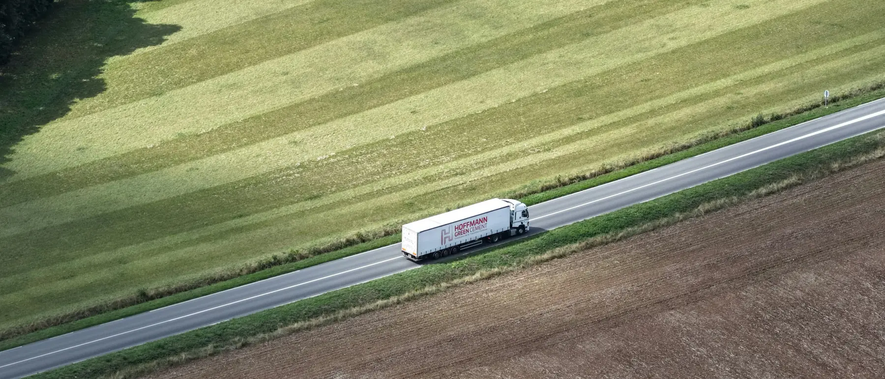 Aerial view of a truck on a highway running through open farmland