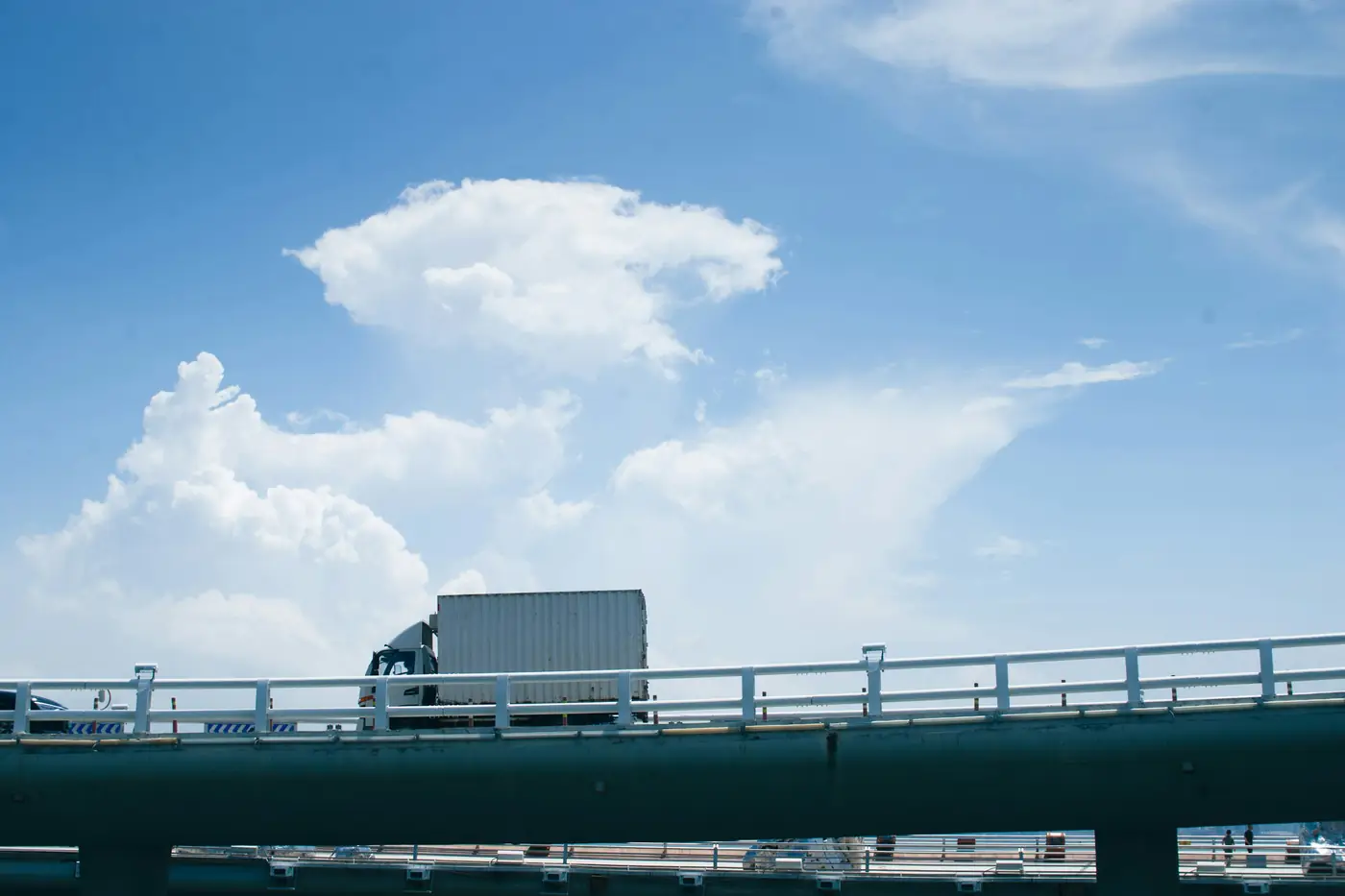 Transport truck crossing a bridge under a clear sky