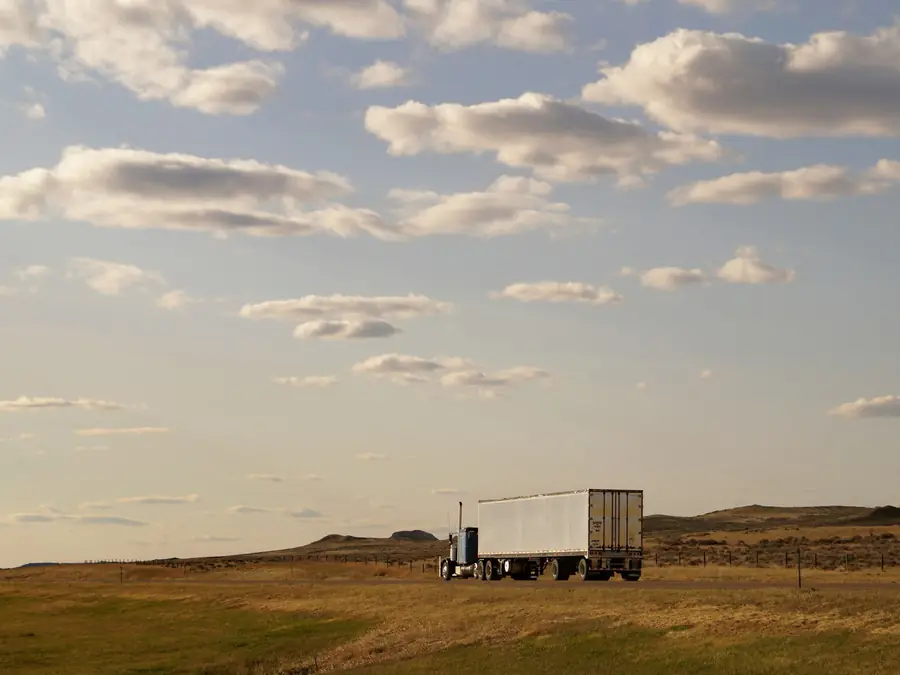 A tractor unit and dry van trailer on an open road